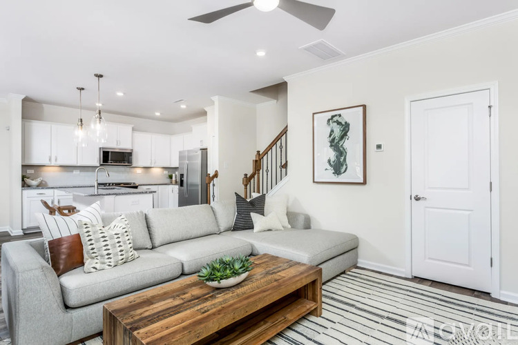 A modern living room with a grey sofa and a wooden coffee table.
