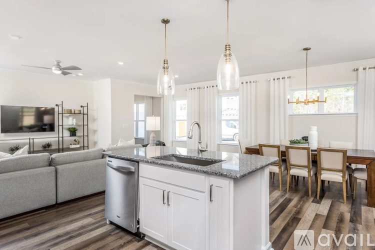A modern kitchen with a large island and a dining table.