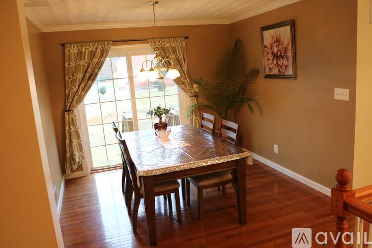 A dining room with a wooden table and chairs.