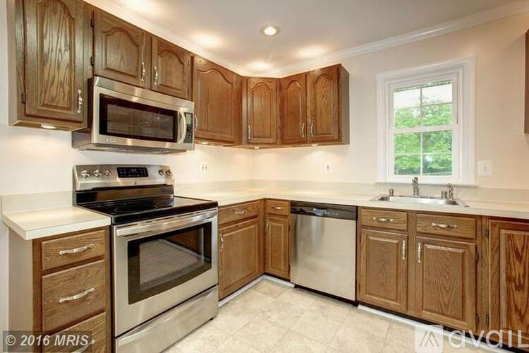 A kitchen with wooden cabinets and stainless steel appliances.