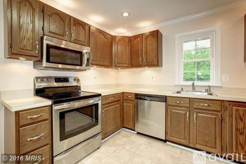 A kitchen with wooden cabinets and stainless steel appliances.
