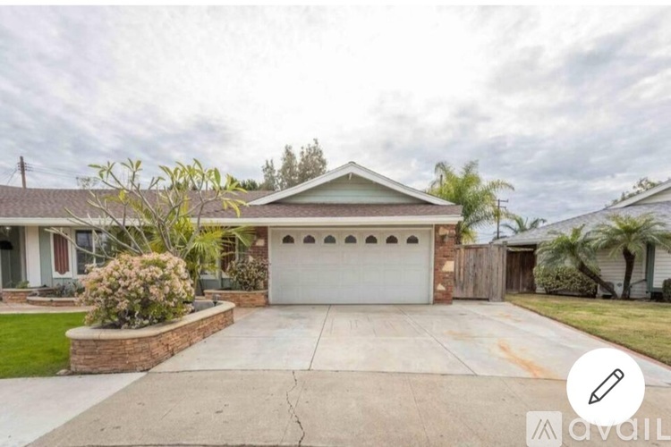 A house with a white garage door and a brick wall.