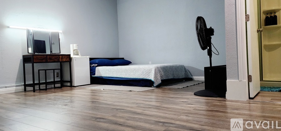 A bedroom with a bed, dresser, and mirror.