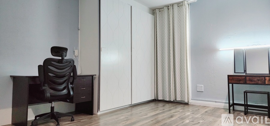 A room with a desk and a chair in it.