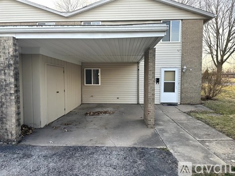 A detached garage with a white door and a window.
