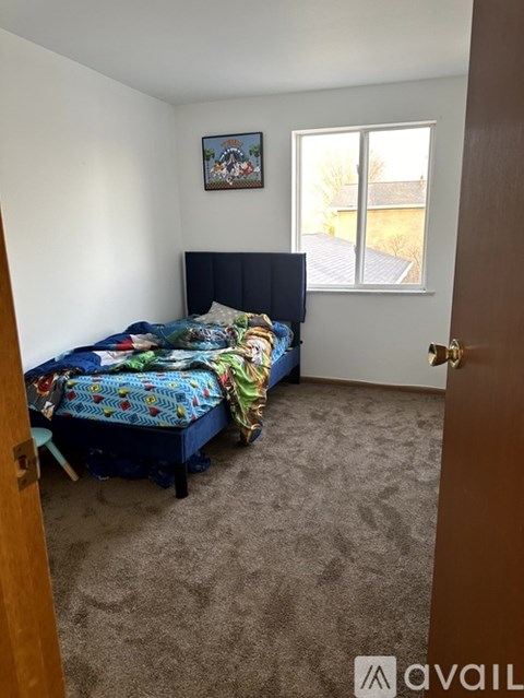 A bedroom with a bed and a painting on the wall.