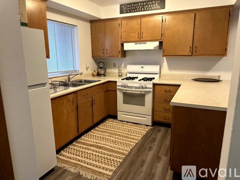 A kitchen with wooden cabinets and a white fridge.