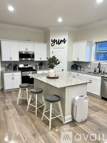 A kitchen with white cabinets and a central island with a plant on it.
