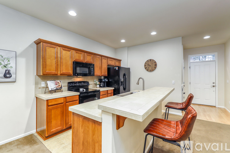 A kitchen with wooden cabinets and a white island.