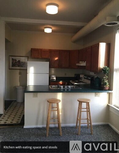 A kitchen with a bar and stools.