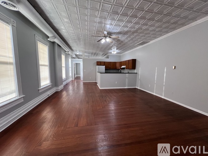 A room with wooden flooring and a ceiling fan.