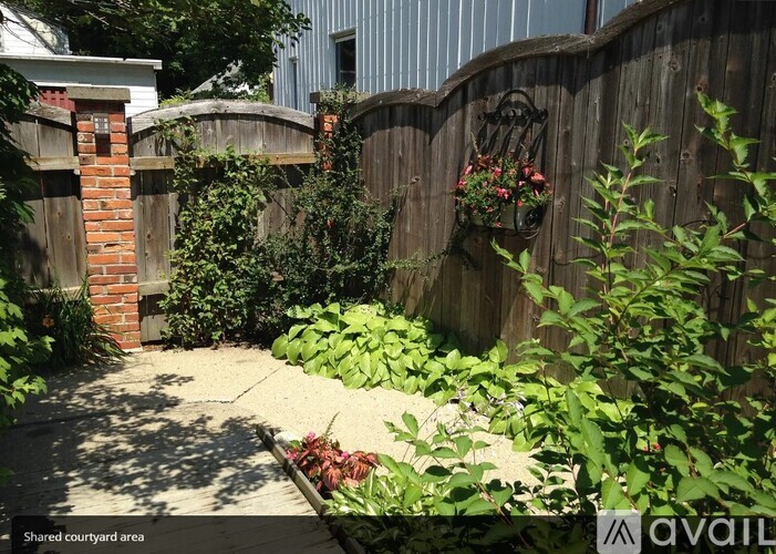 A garden area with a wooden fence and a brick pillar.