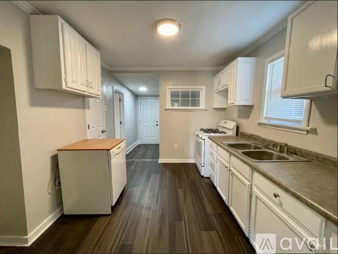 A kitchen with white cabinets and a wooden countertop.