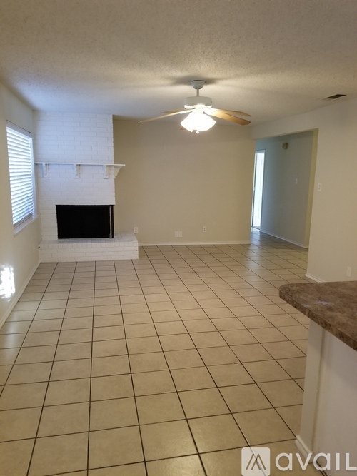 A living room with a fireplace and tiled flooring.