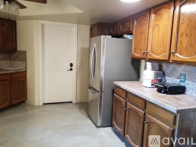 A kitchen with wooden cabinets and a refrigerator.