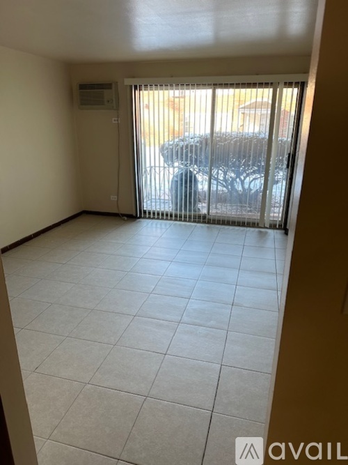 A room with a tiled floor and a sliding glass door leading to a balcony.