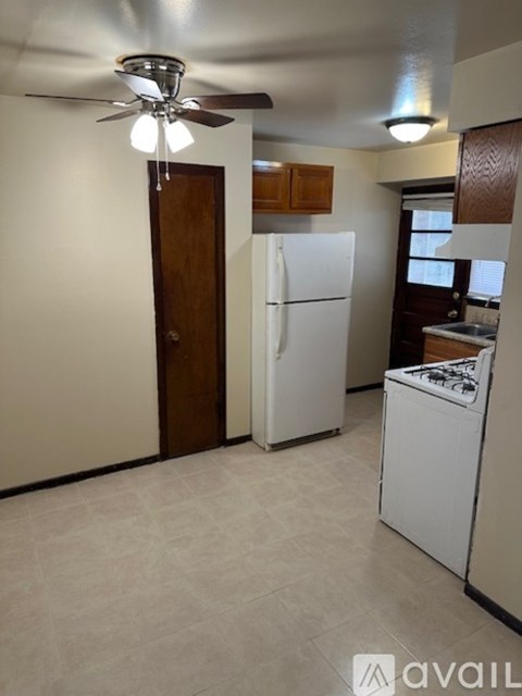 A kitchen with a white fridge and a white stove top oven.