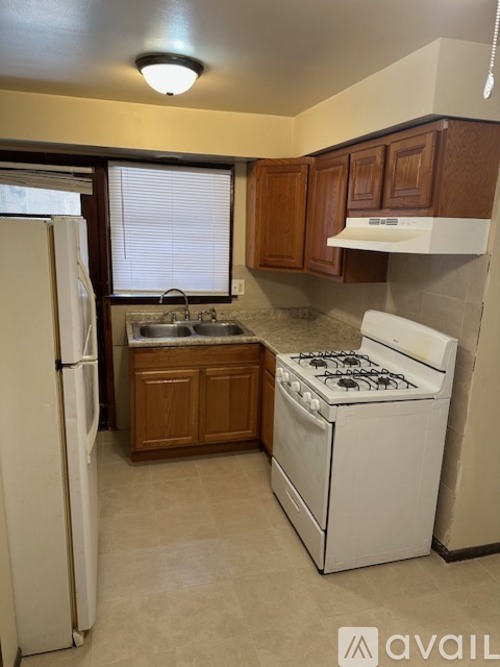 A small kitchen with a white fridge and a white stove.