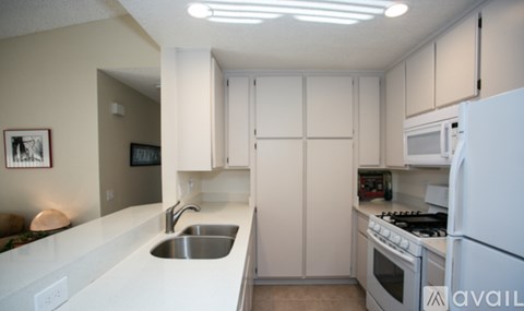 A kitchen with white cabinets and appliances.