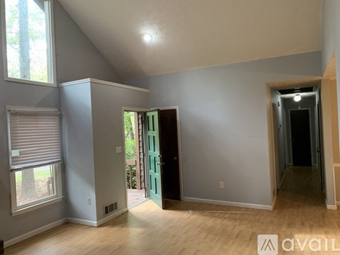 A room with a window and a door leading outside.