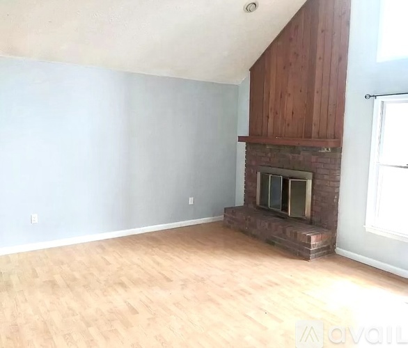 A room with a fireplace and wooden floors.