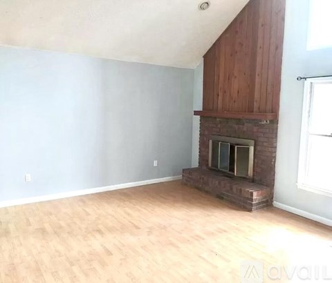 A room with a fireplace and wooden floors.