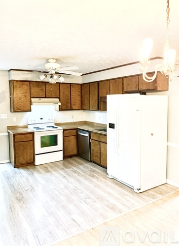 A kitchen with a white fridge and wooden cabinets.