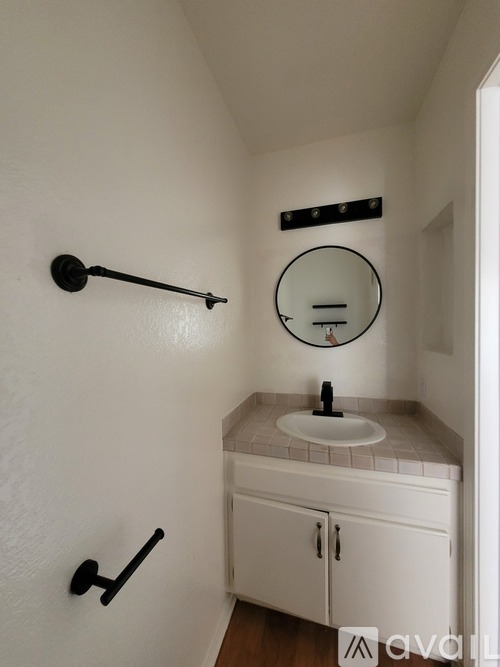 A white bathroom with a sink and a mirror.