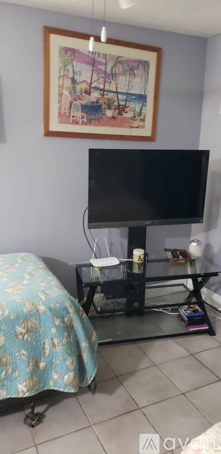 A living room with a television and a painting on the wall.
