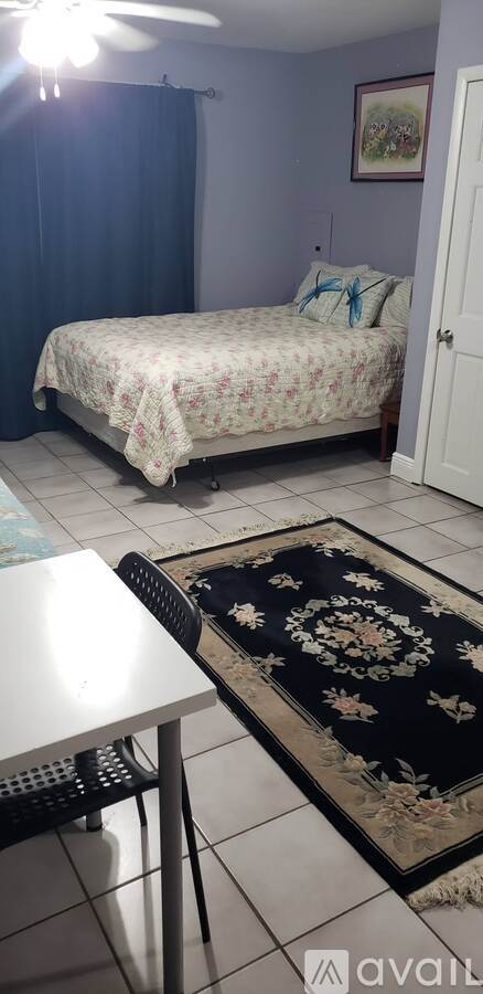 A bedroom with a bed and a rug on the floor.