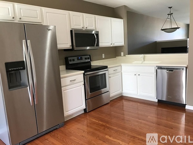 A kitchen with a refrigerator, microwave, oven, and dishwasher.