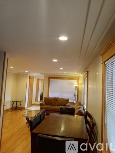 A living room with a wooden table and chairs.