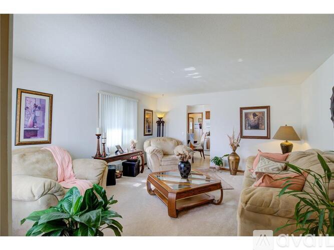 A living room with a white couch, a coffee table, and a pink throw blanket.
