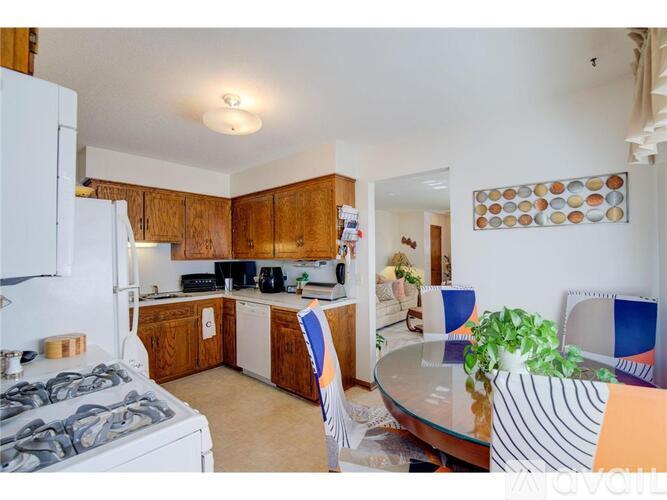 A kitchen with wooden cabinets and a white fridge.