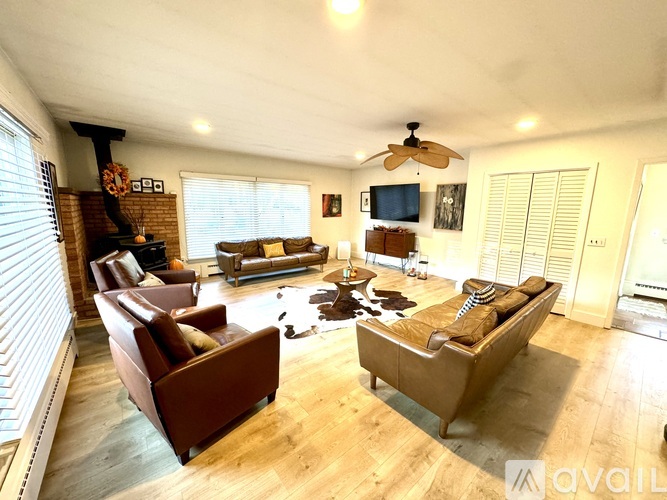 A living room with a brown couch and a ceiling fan.