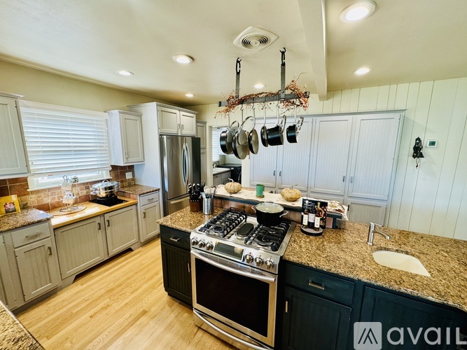 A kitchen with a granite countertop and a stove top oven.