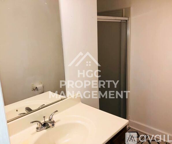 A white sink in a bathroom with a mirror above it.