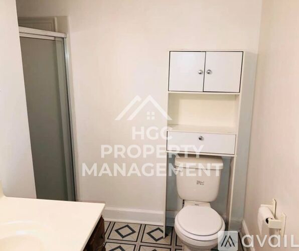 A white toilet in a small bathroom with a sign that says HGCP.