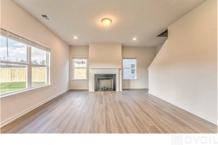 A spacious living room with a fireplace and hardwood floors.