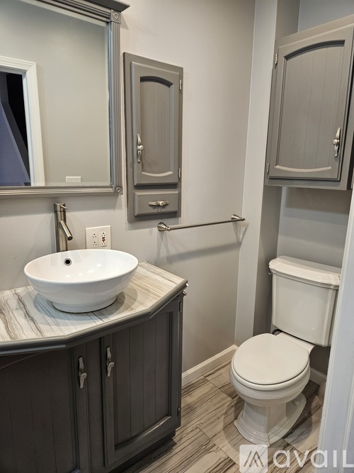 A bathroom with a white toilet and a sink with a marble counter.