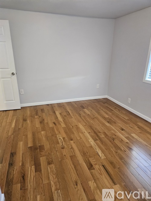 A room with wooden flooring and a white door.