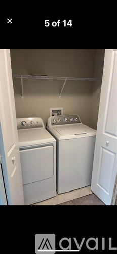 A laundry room with two washing machines and a door.