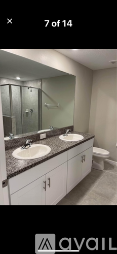 A bathroom with two sinks and a toilet.