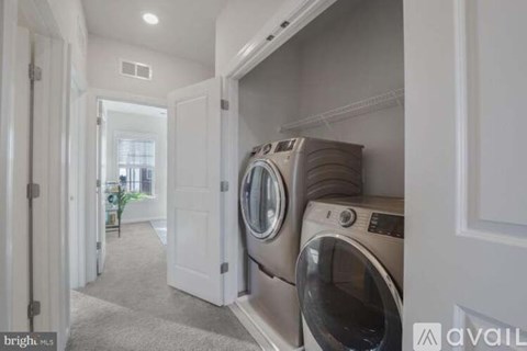A laundry room with a washer and dryer stacked on top of each other.