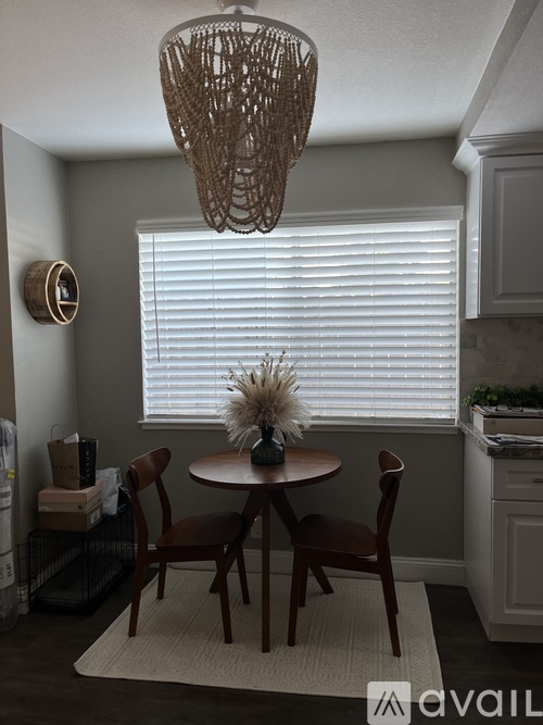 A dining room with a round table and chairs.