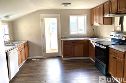 A kitchen with wooden cabinets and a white dishwasher.