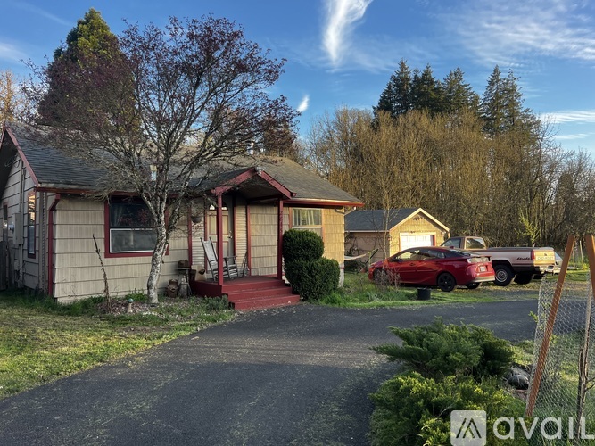 A house with a red car parked in front.