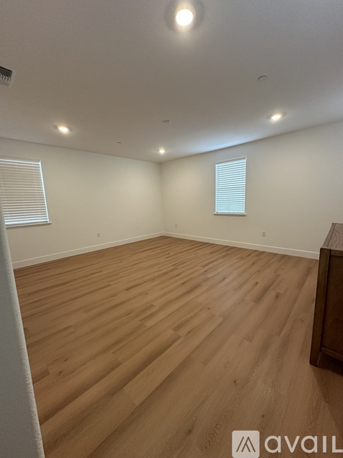 A room with wooden flooring and white walls.