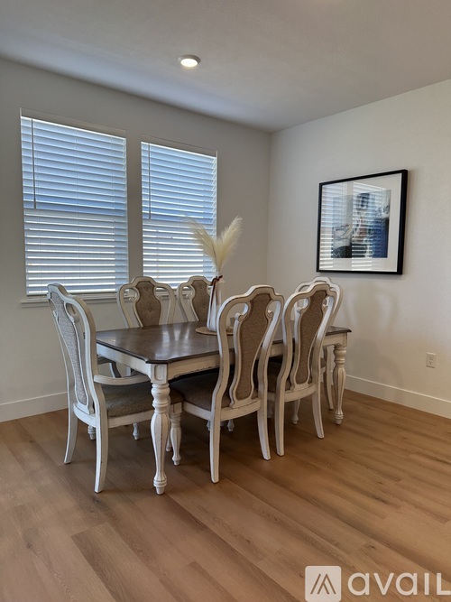A dining room with a table and chairs.