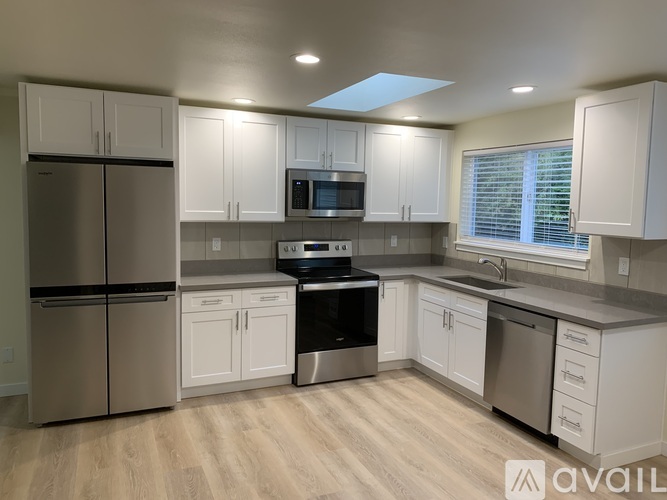 A kitchen with white cabinets and stainless steel appliances.